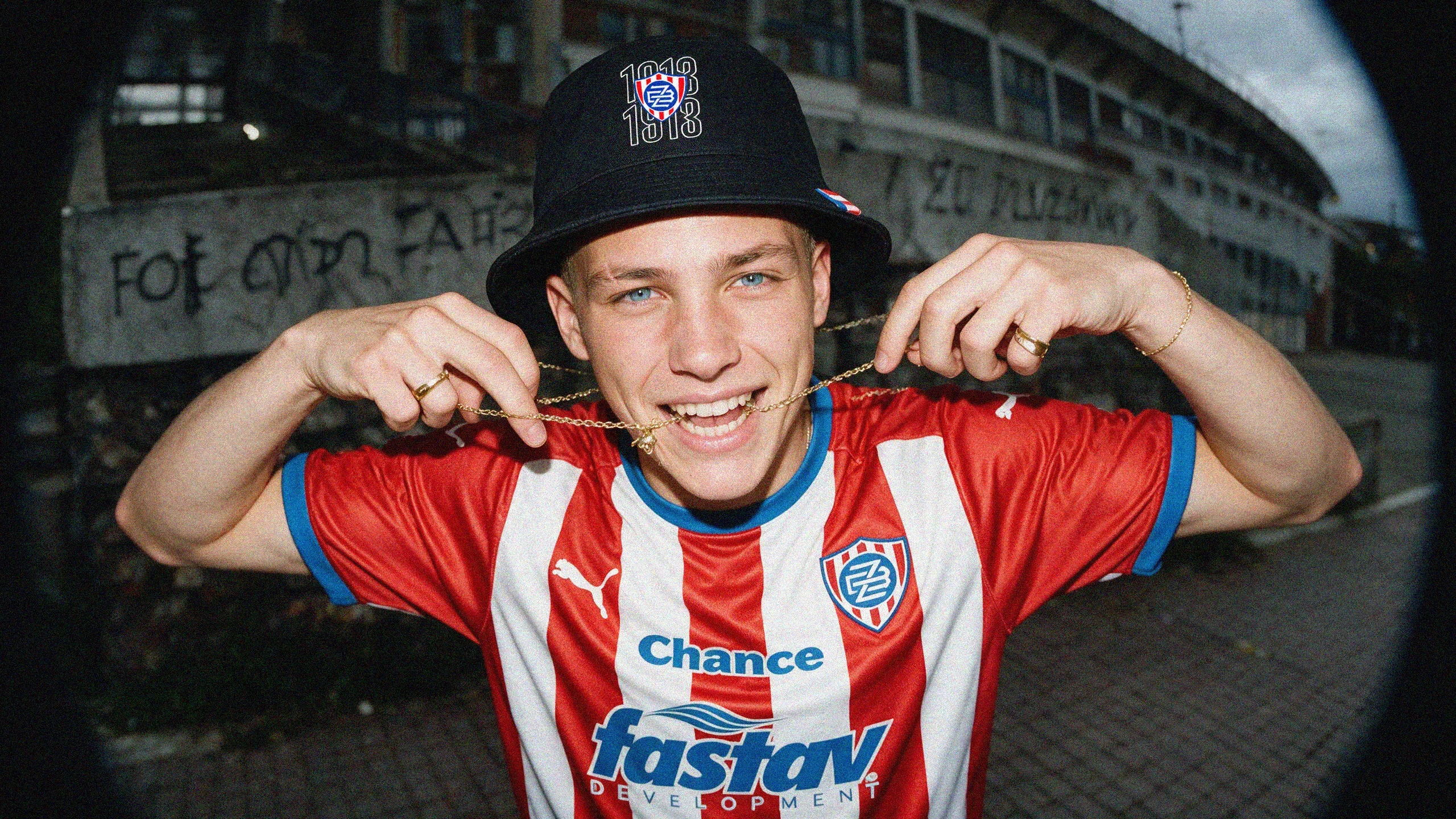 Fan in a Zbrojovka kit and bucket hat outside the stadium